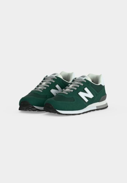 Par de zapatillas New Balance verde oscuro con el logo blanco "N", cordones grises y medias suelas blancas sobre un fondo blanco liso.