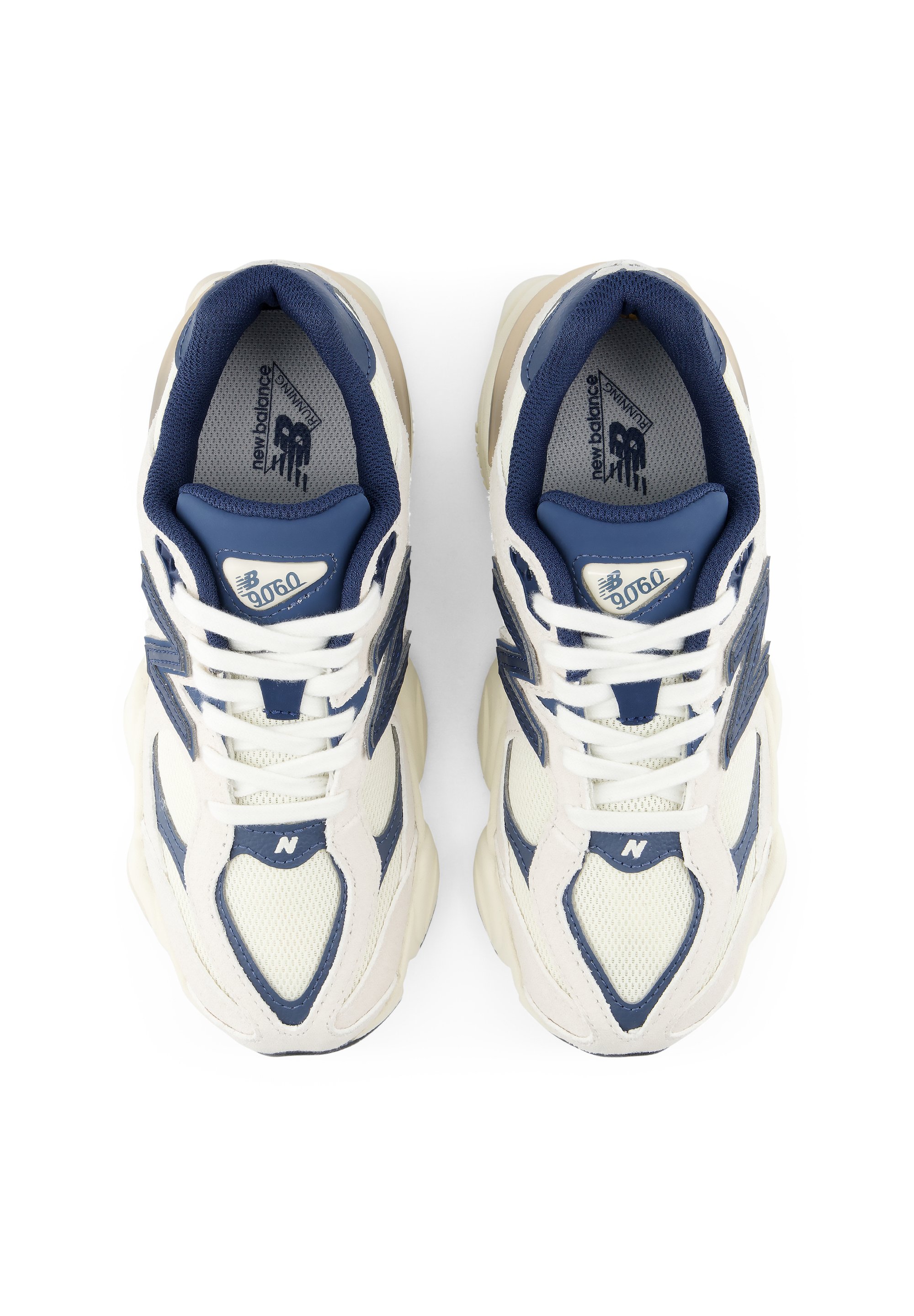 Par de zapatillas de deporte New Balance 9060 blancas y azul marino vistas desde arriba con cordones blancos y suelas voluminosas.