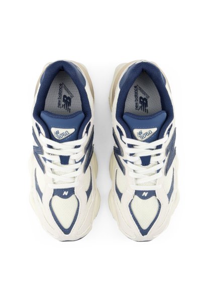 Par de zapatillas de deporte New Balance 9060 blancas y azul marino vistas desde arriba con cordones blancos y suelas voluminosas.
