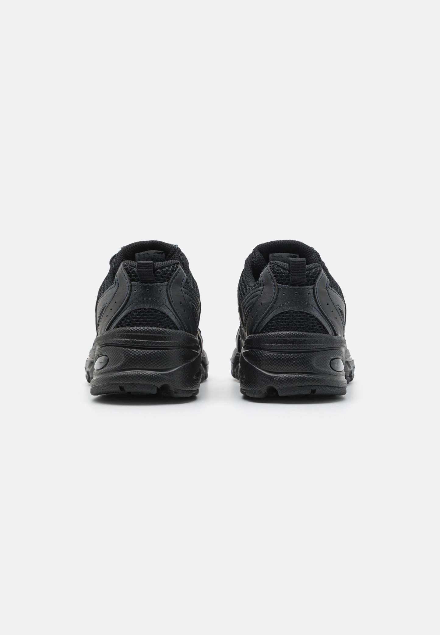 Zapatillas deportivas negras con parte superior de malla y suela de goma, que cuentan con acentos texturizados, tacón redondeado y una lengüeta en la parte trasera para facilitar el calzado.