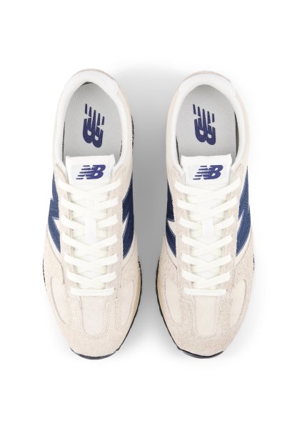 Zapatillas con parte superior de ante color beige, detalles laterales en azul marino y cordones blancos. Presentan una lengüeta acolchada y un logo en la plantilla. Diseño de puntera redonda.