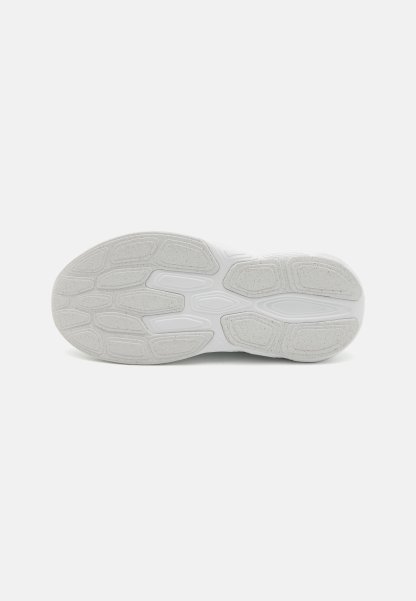 Suela de zapatilla blanca con un patrón de agarre de goma texturizada y secciones de tonos contrastantes más claros y más oscuros. Diseño plano y deportivo.