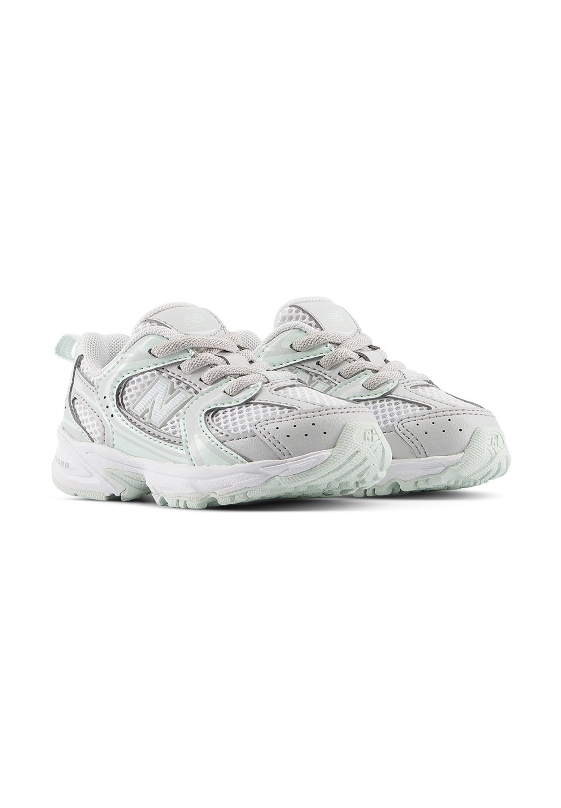 Par de zapatillas deportivas gris claro y blancas con paneles de malla, cordones y suelas de goma texturizadas, mostradas una al lado de la otra sobre fondo blanco.