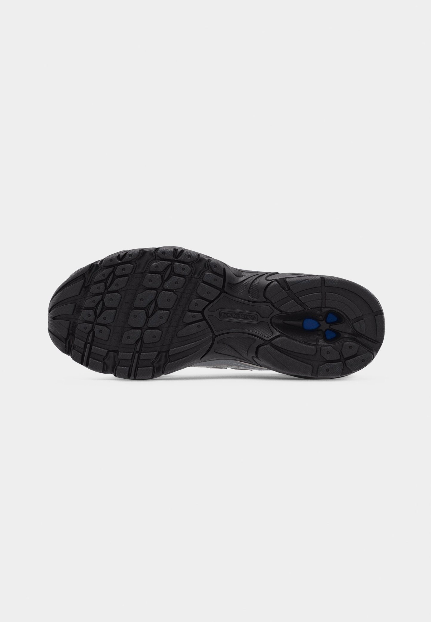 Suela de zapato de goma negra con patrón de tracción texturizado, ranuras profundas y pequeños acentos azules cerca del área del talón.