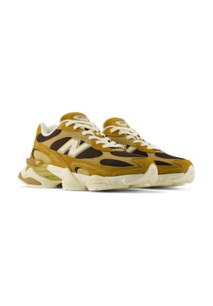 Par de zapatillas New Balance marrones y beige con cordones blancos y suela gruesa, inclinadas para mostrar los laterales exteriores sobre un fondo blanco.