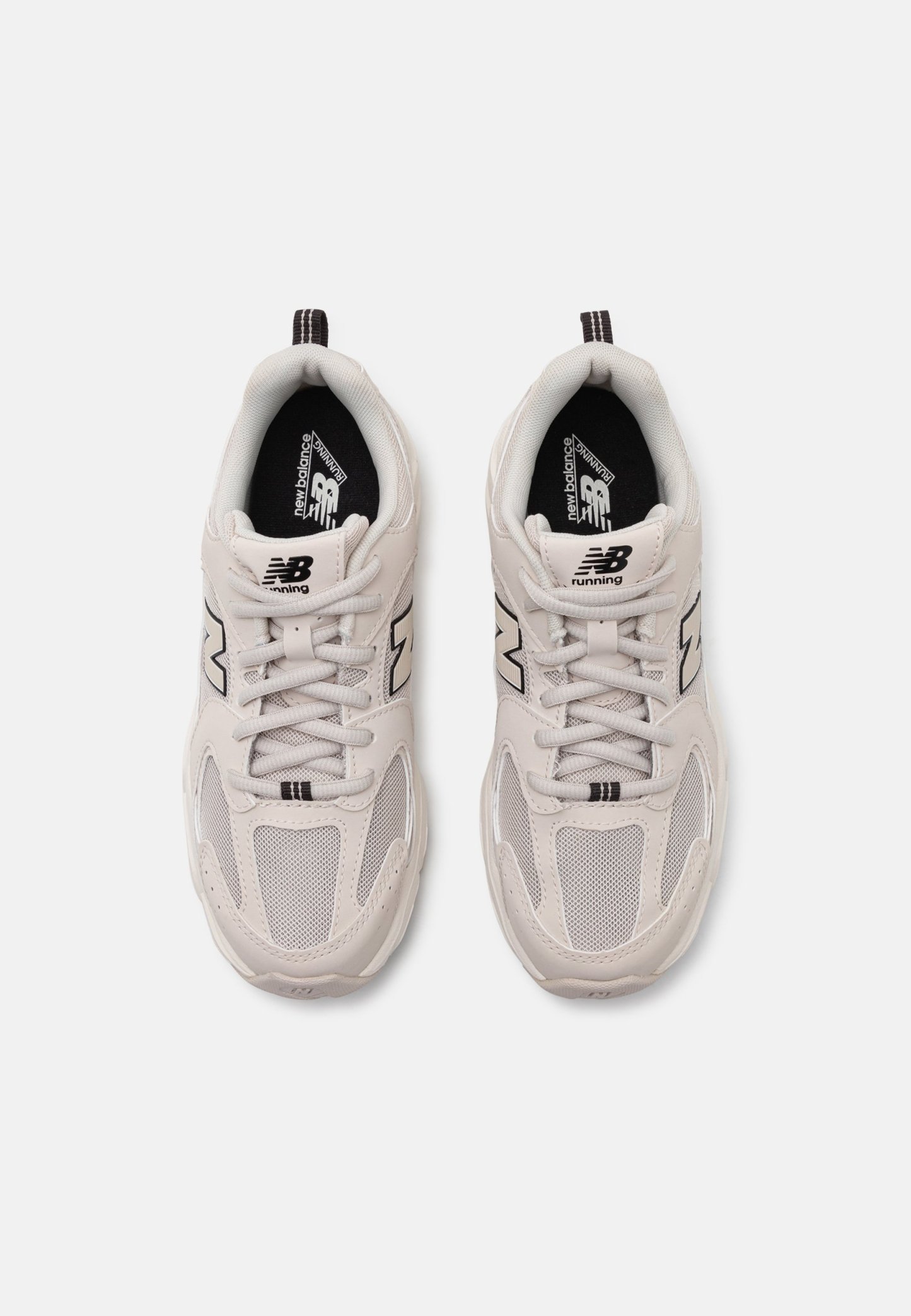 Zapatillas de running gris claro que presentan materiales de malla y sintéticos, con acentos negros y un distintivo logo "N" en los laterales.
