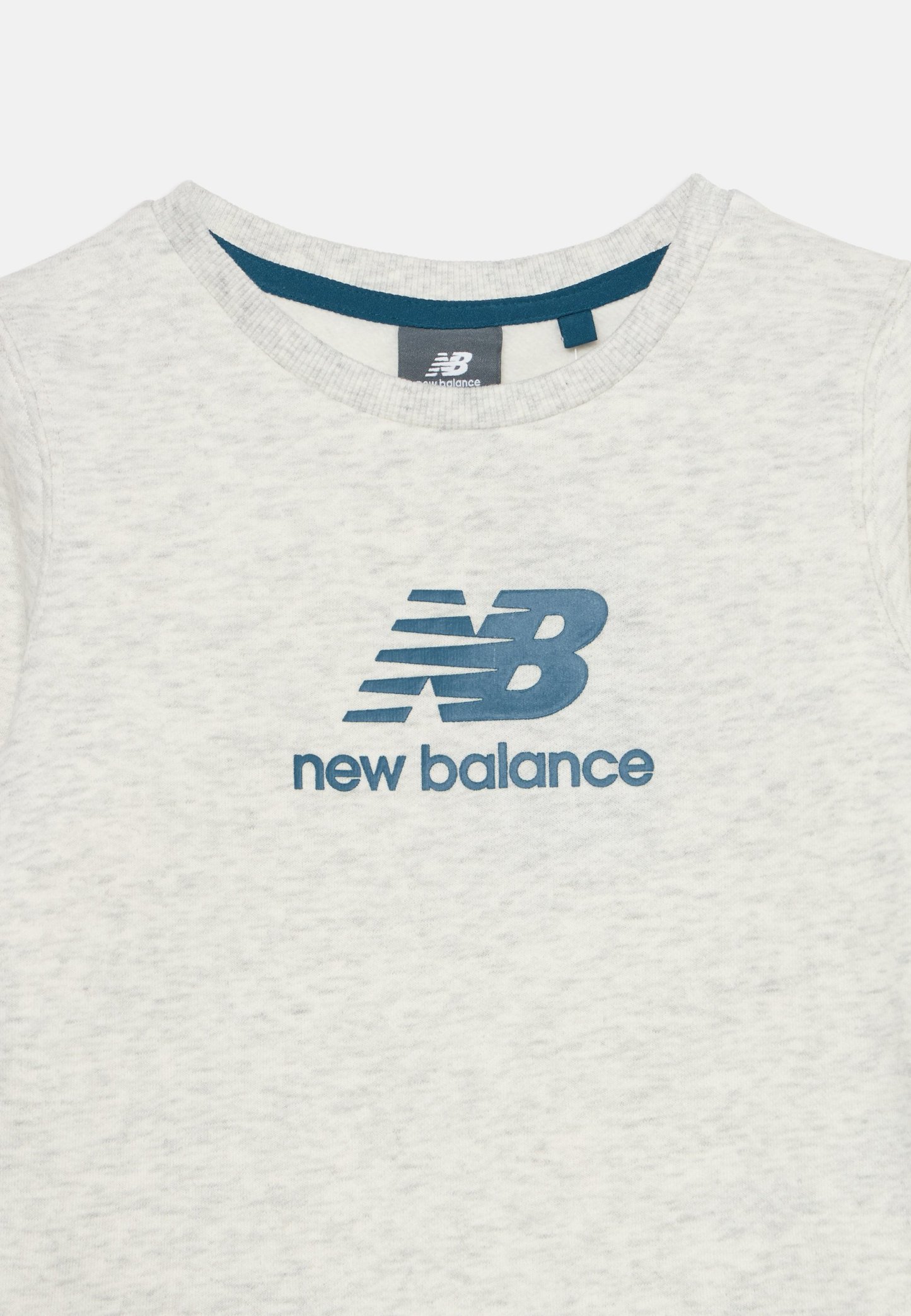 Camiseta New Balance gris claro con logo azul y nombre de la marca impreso en el pecho y cuello redondo con ribete azul.