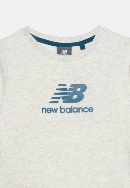 Camiseta New Balance gris claro con logo azul y nombre de la marca impreso en el pecho y cuello redondo con ribete azul.