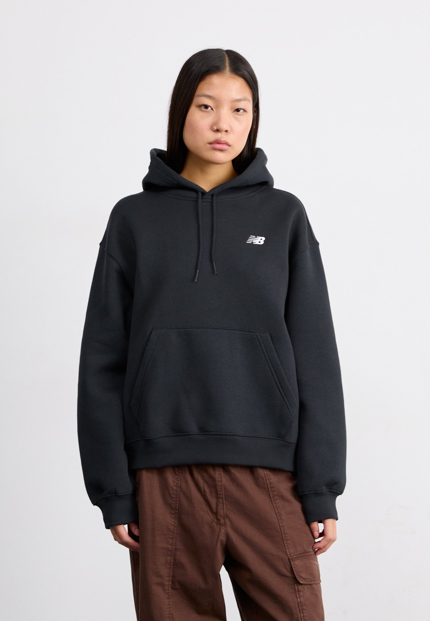 Sudadera con capucha negra hecha de una mezcla de algodón, con un bolsillo delantero tipo canguro y un pequeño logo blanco en el pecho.