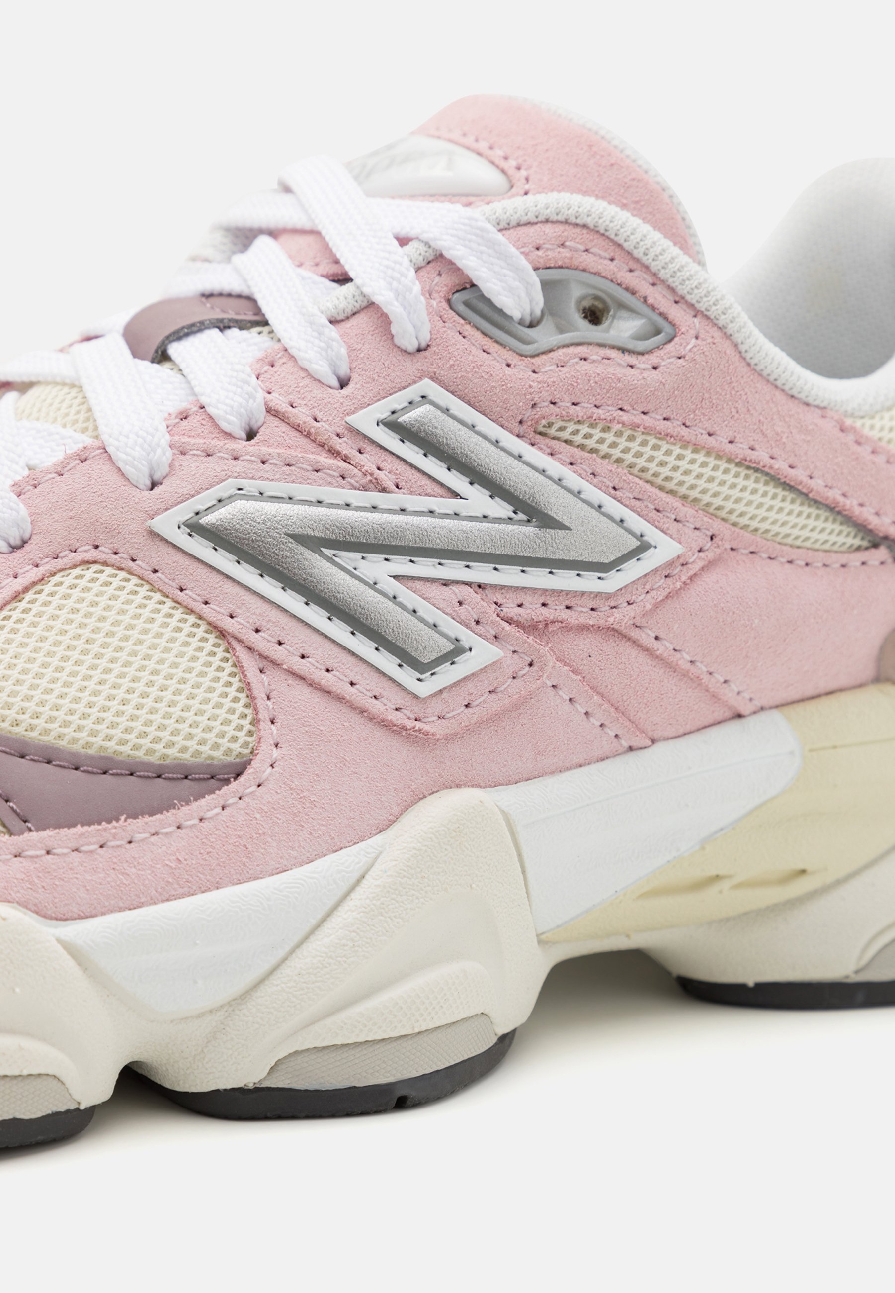 Zapatillas en color rosa y beige con materiales de gamuza y malla. Cuenta con una entresuela blanca gruesa, suela de goma y acentos de logo plateado en el costado.