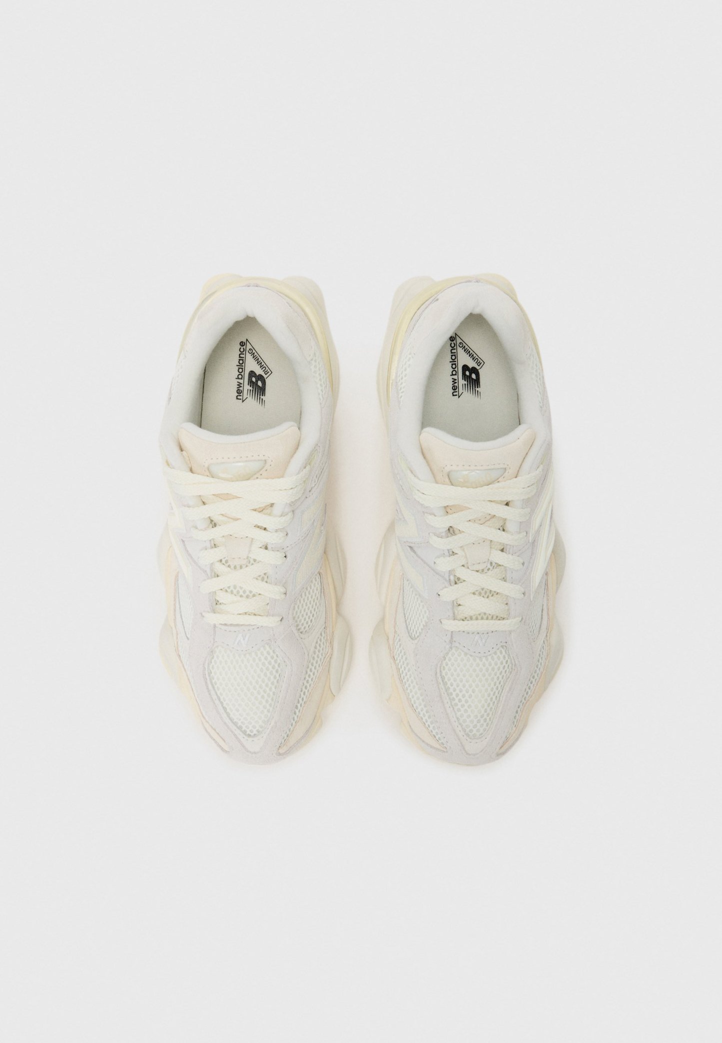 Zapatillas de malla blanca y ante con acentos en crema, suela gruesa y cordones redondos. Presenta un logotipo en la lengüeta y en el lateral.