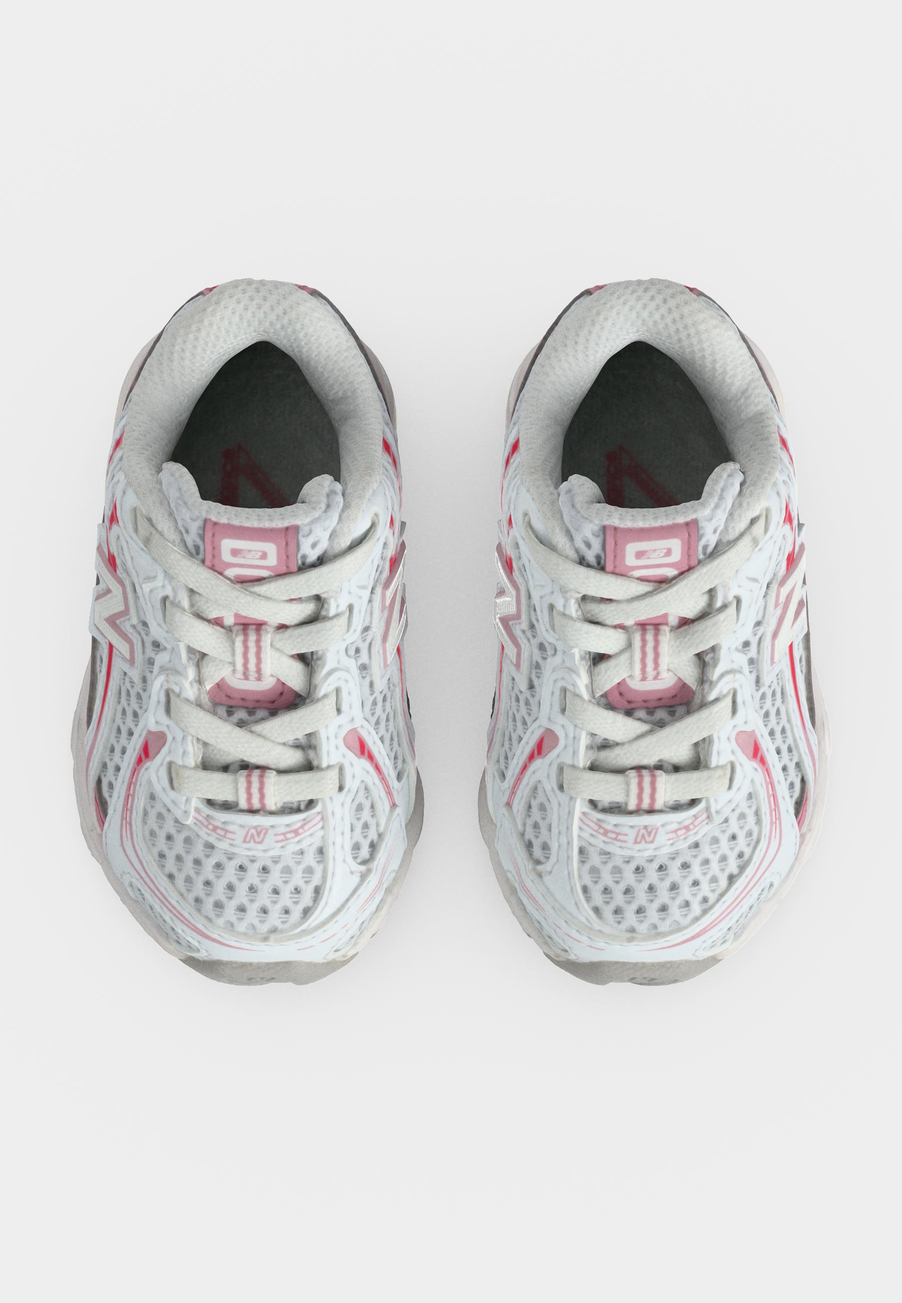 Par de zapatillas deportivas de malla blancas y rosas vistas desde arriba, con cordones atados y logo visible de la marca en los laterales.