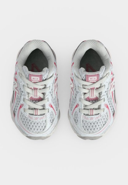 Par de zapatillas deportivas de malla blancas y rosas vistas desde arriba, con cordones atados y logo visible de la marca en los laterales.