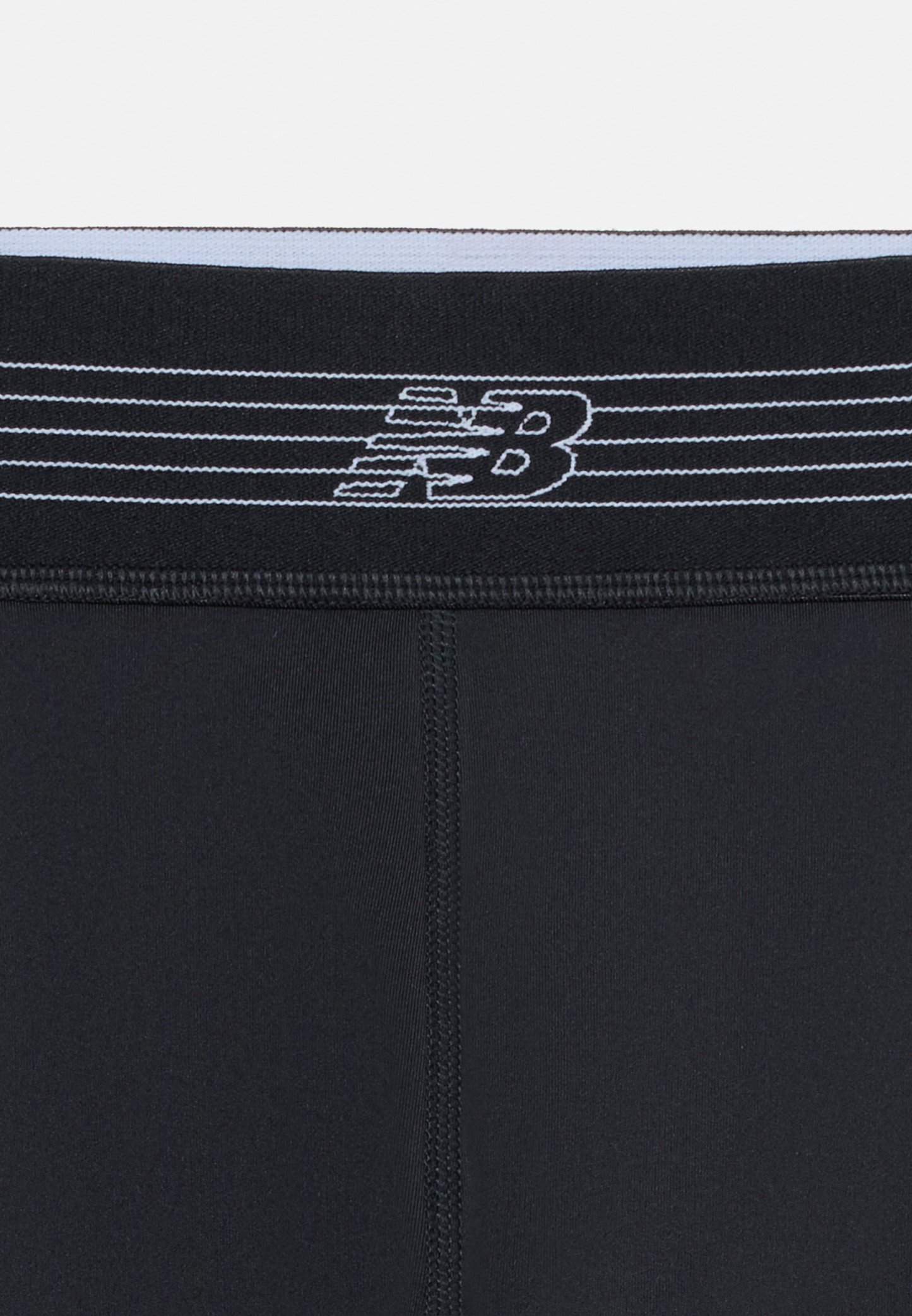 Leggings deportivos negros con costura central cosida y cintura negra con patrón de rayas blancas y logo de New Balance.