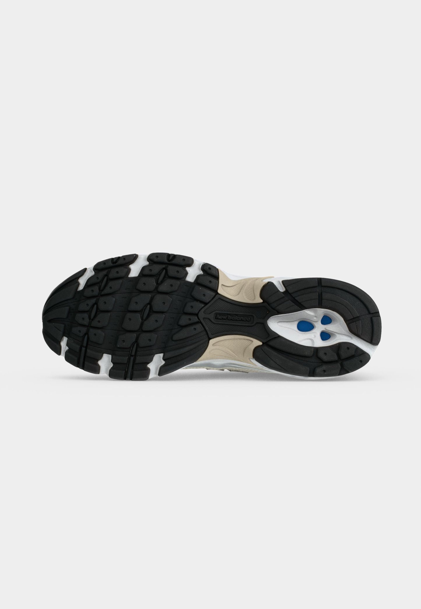 Suela de un zapato deportivo beige y negro con suela texturizada y detalles azules en el talón para agarre y soporte.