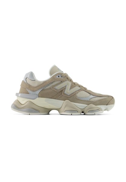 Zapatilla deportiva de color beige claro y crema con parte superior de malla y ante, suela gruesa esculpida y logo de New Balance en el lateral.
