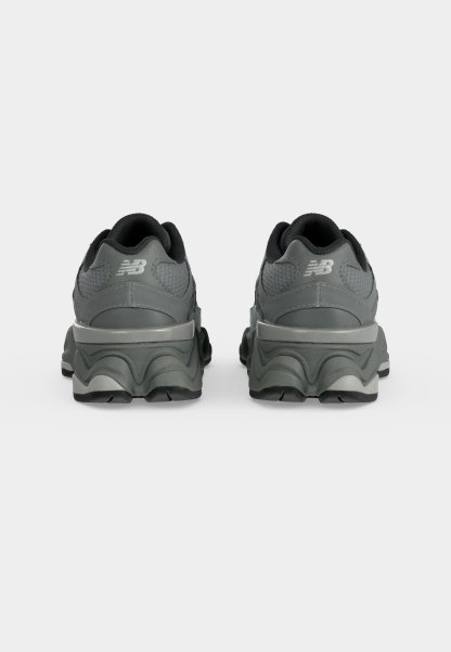 Par de zapatillas New Balance de color gris oscuro vistas desde atrás, con suelas gruesas y cuellos acolchados.