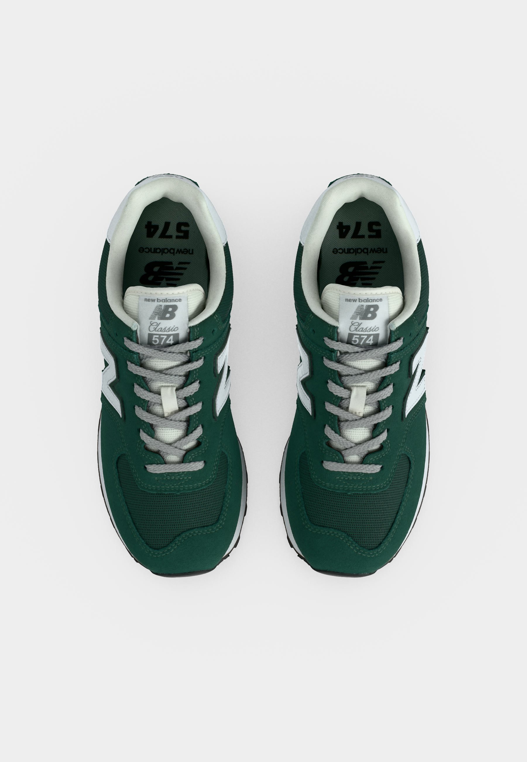 Par de zapatillas New Balance 574 Classic verdes y blancas vistas desde arriba sobre un fondo blanco.