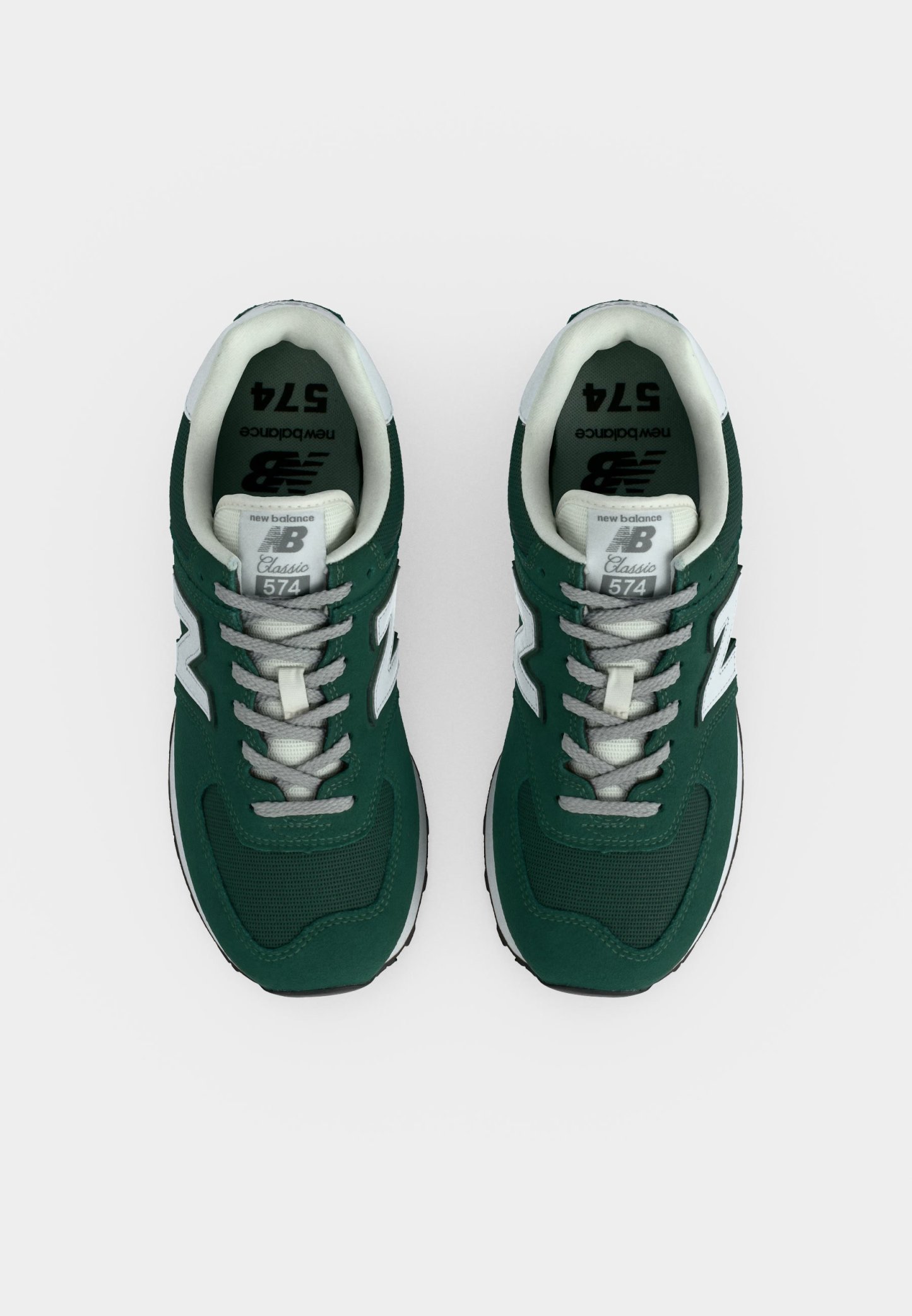 Par de zapatillas New Balance 574 Classic verdes y blancas vistas desde arriba sobre un fondo blanco.