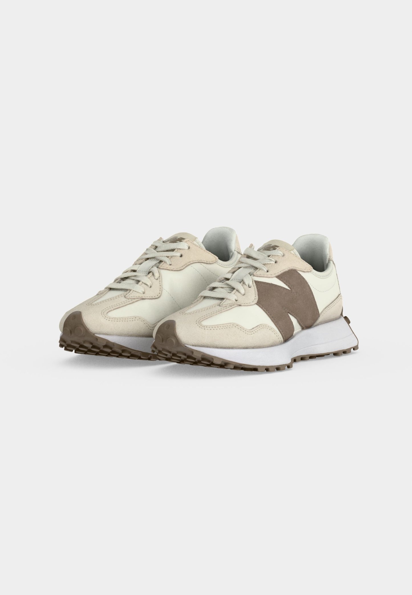 Par de zapatillas casuales beige y marrón claro con cordones, suelas texturizadas y un gran logo "N" en los laterales, mostradas sobre un fondo claro liso.