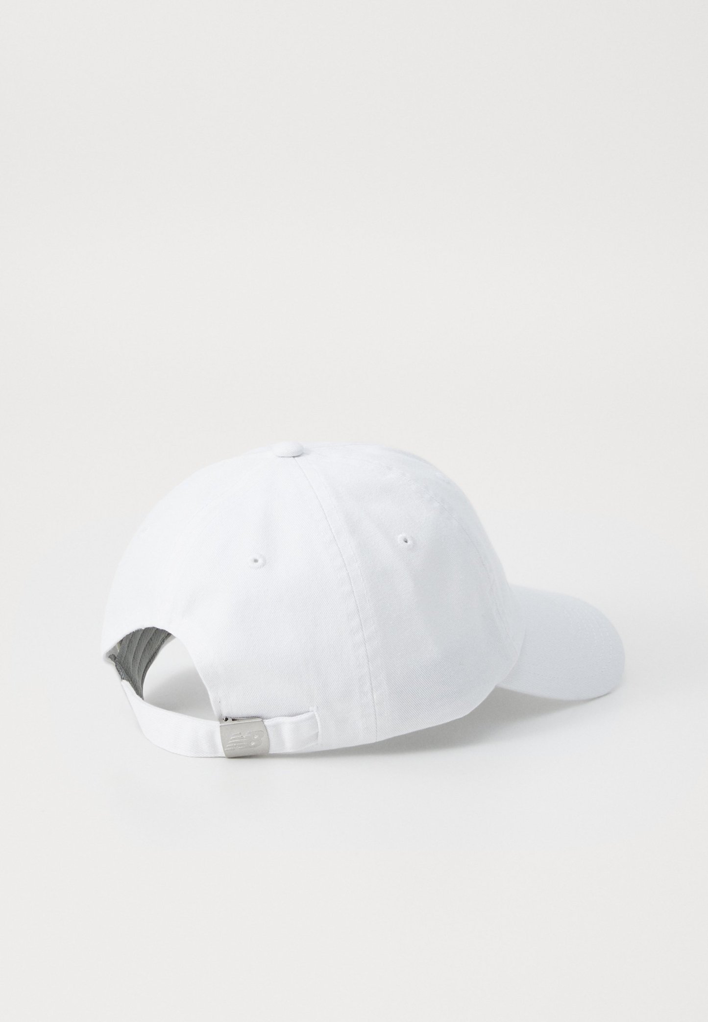 Gorra de béisbol blanca de algodón con visera curvada, correa de metal ajustable en la parte posterior y un suave forro interior. Diseño sencillo, sin patrones.