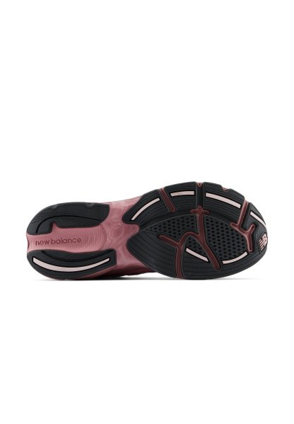 Suela de un zapato New Balance que muestra un diseño de dibujo en negro y rosa con agarre texturizado y el nombre de la marca en la zona del talón.