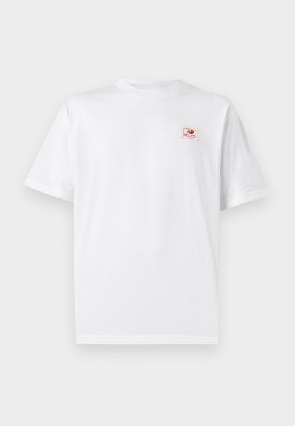 Camiseta blanca de manga corta con cuello redondo y un pequeño parche con el logo de New Balance en rojo en el pecho izquierdo.