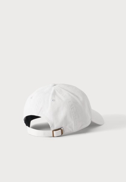 Gorra de béisbol blanca mostrada desde atrás con una correa de tela ajustable y hebilla de metal sobre un fondo claro y liso.