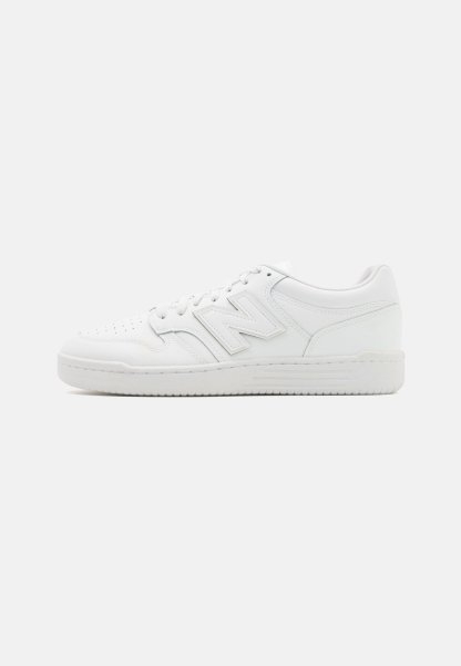 Zapatilla blanca hecha de cuero suave, con puntera perforada, suela de goma texturizada, cordones planos y un prominente logo 'N' en el lateral.