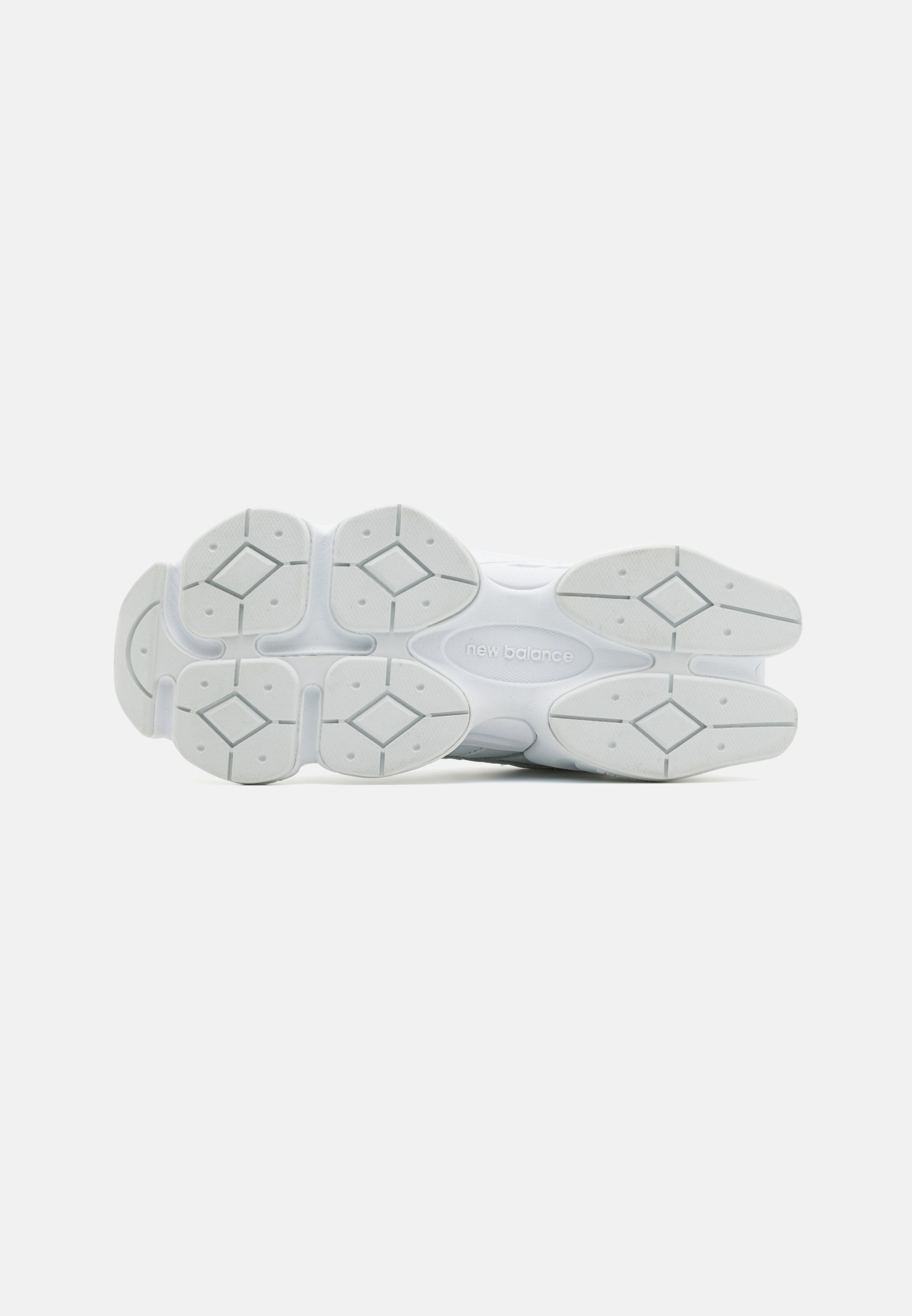 Suela de zapato deportivo blanco con patrón de goma texturizada, con formas de diamante y el logotipo de "New Balance" en la entresuela.