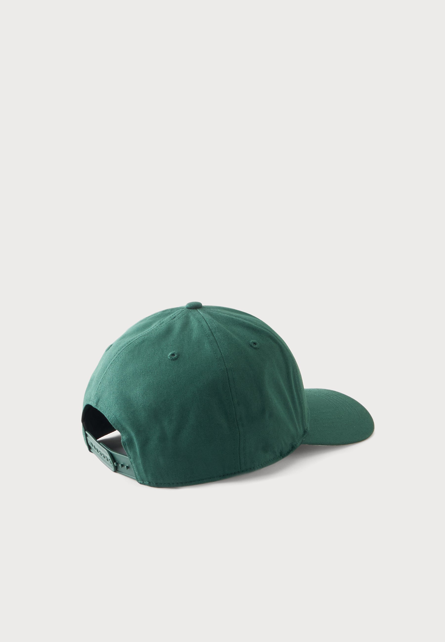 Gorra de béisbol verde oscuro vista por detrás con correa ajustable y ojales de ventilación sobre un fondo liso y claro.