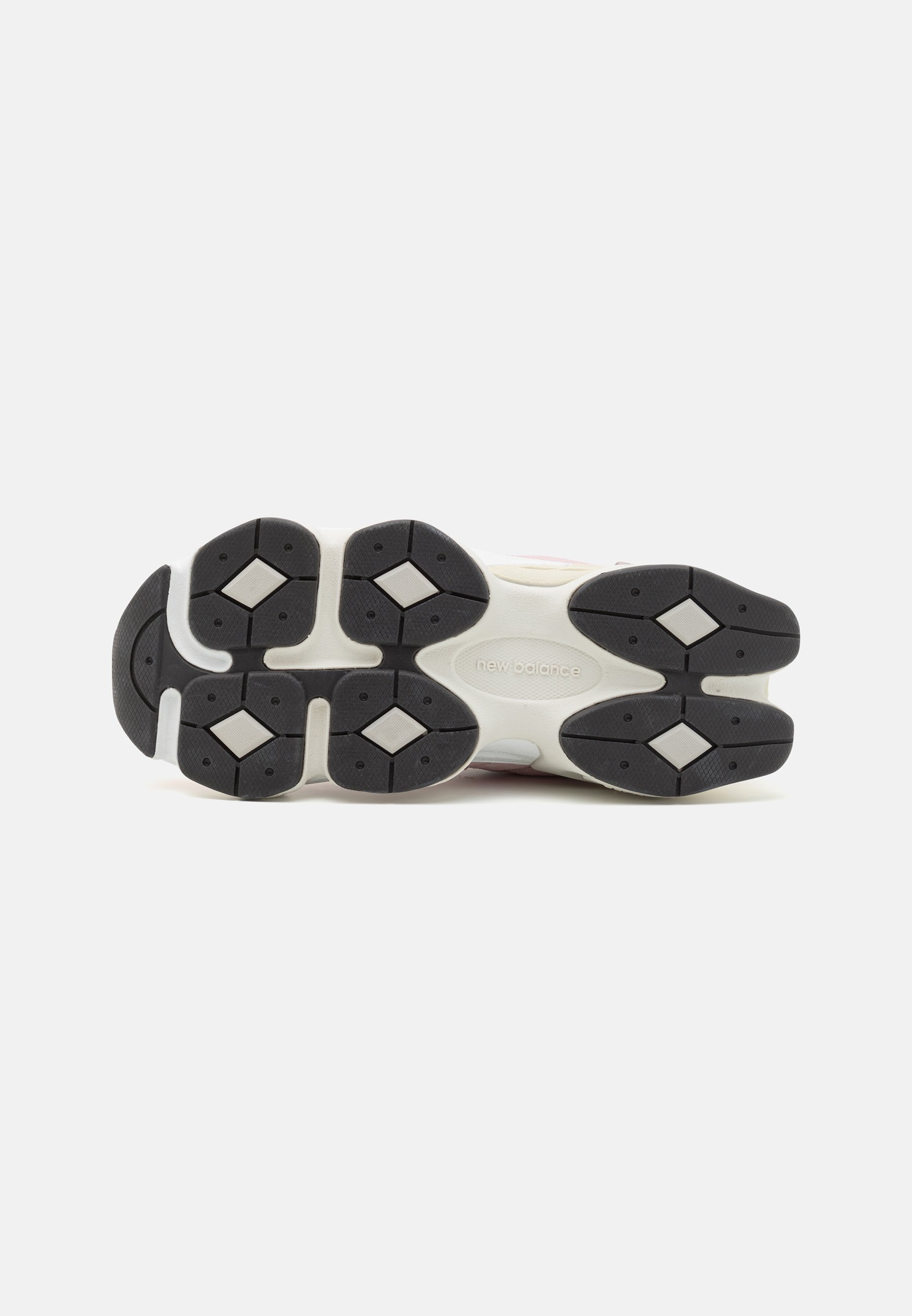 Suela de zapato con una base de goma negra con acentos blancos, patrones de banda de rodadura hexagonales y un logo de "new balance" grabado.