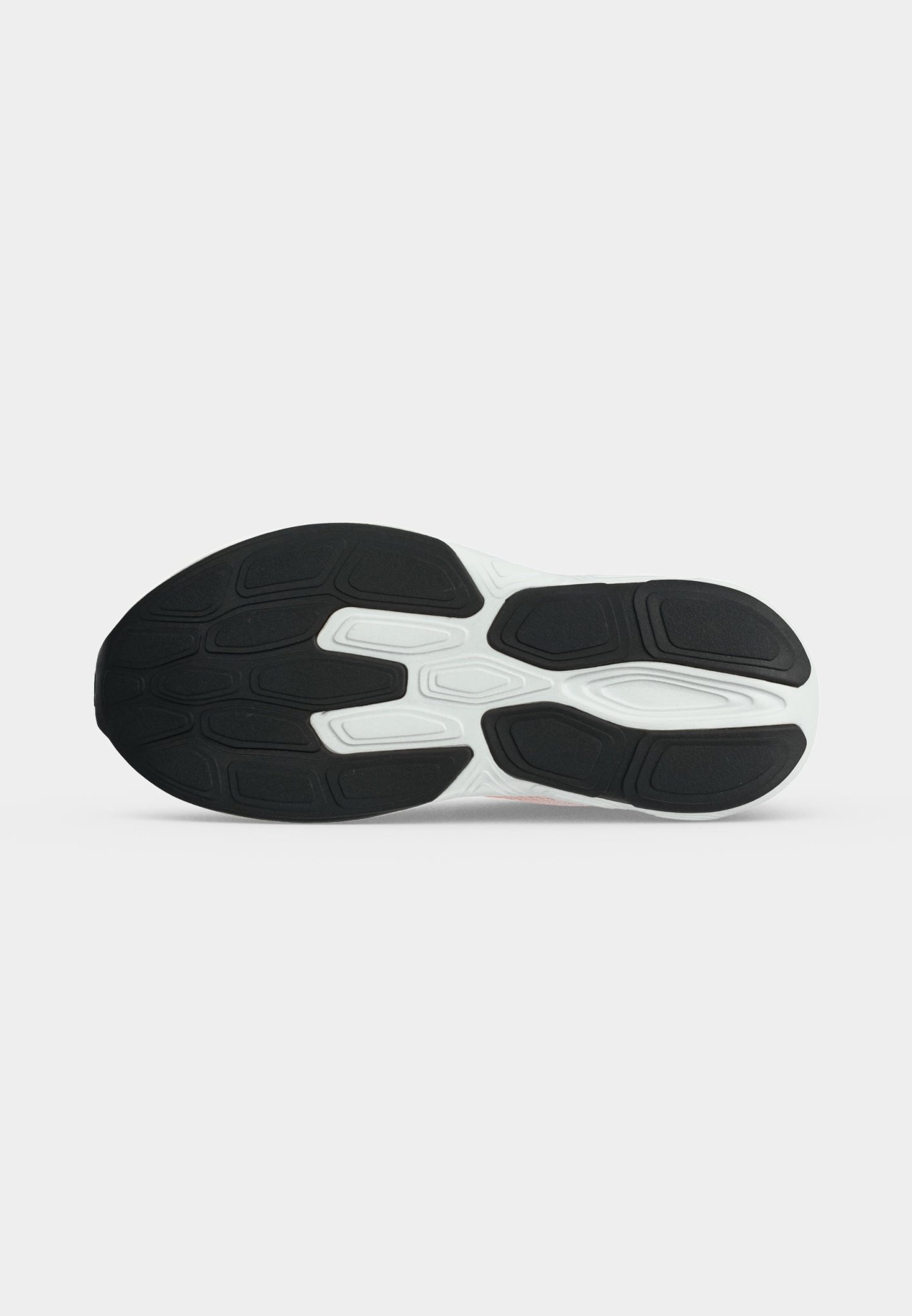 Suela de un zapato deportivo con patrones de goma en blanco y negro diseñados para agarre y durabilidad.