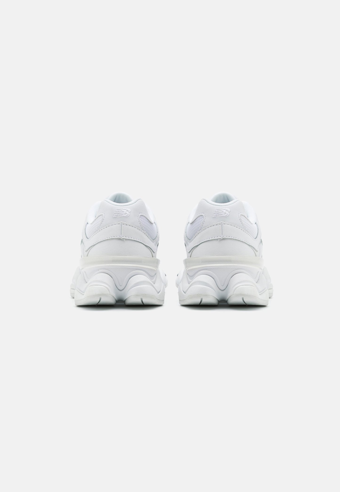 Zapatillas deportivas blancas con un talón redondeado y acolchado. Materiales de malla y sintéticos con acentos texturizados. Diseño de suela voluminoso para mayor estabilidad.