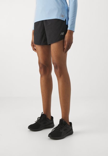 Los pantalones cortos deportivos negros cuentan con una tela ligera y texturizada. Combinados con zapatillas de correr negras, ideales para el uso activo. Top de manga larga de color azul claro.
