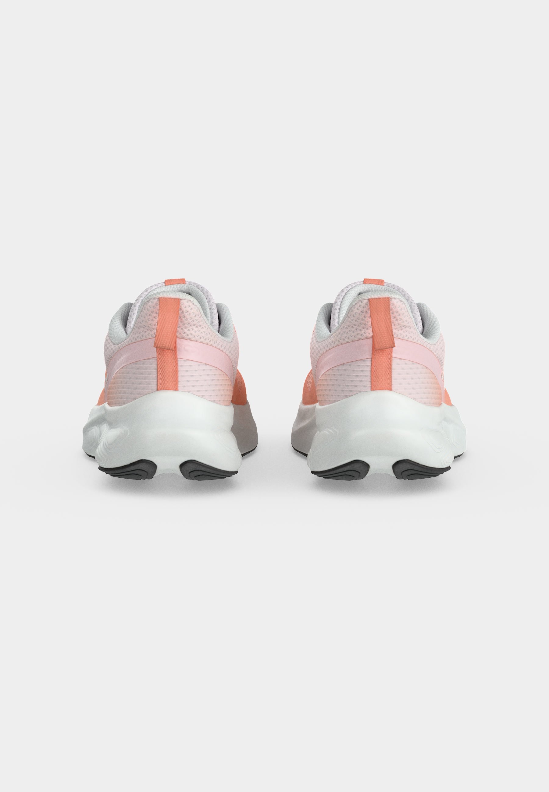 Par de zapatos deportivos de color rosa claro y coral con suelas blancas mostrados desde atrás sobre un fondo blanco liso.