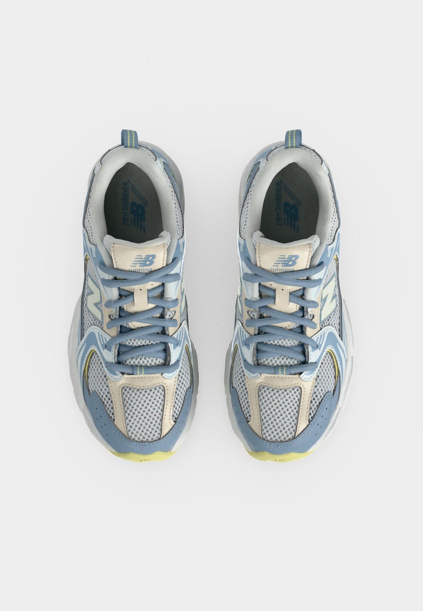 Par de zapatillas de running New Balance azules, grises y blancas vistas desde arriba, con detalles de malla y cuero y cordones azules.