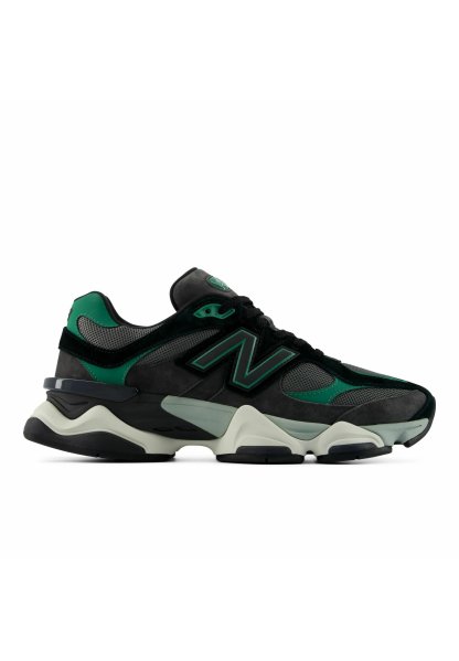 Zapatilla deportiva negra y verde con paneles de malla y ante, suela gruesa bicolor y un gran logo "N" en el lateral.