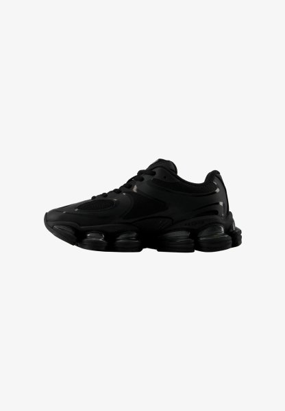 Zapatilla deportiva negra con parte superior de malla y sintético, cierre de cordones en la parte delantera y suela gruesa segmentada diseñada para amortiguación y soporte.
