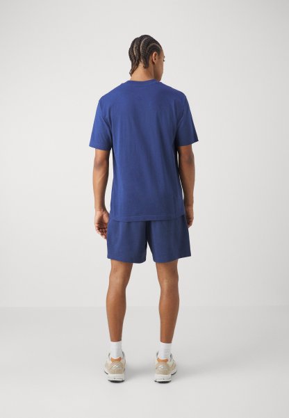 Conjunto de camiseta de algodón color azul marino y pantalones cortos, con un corte holgado. El material parece suave, con un diseño sencillo y un mínimo de detalles.