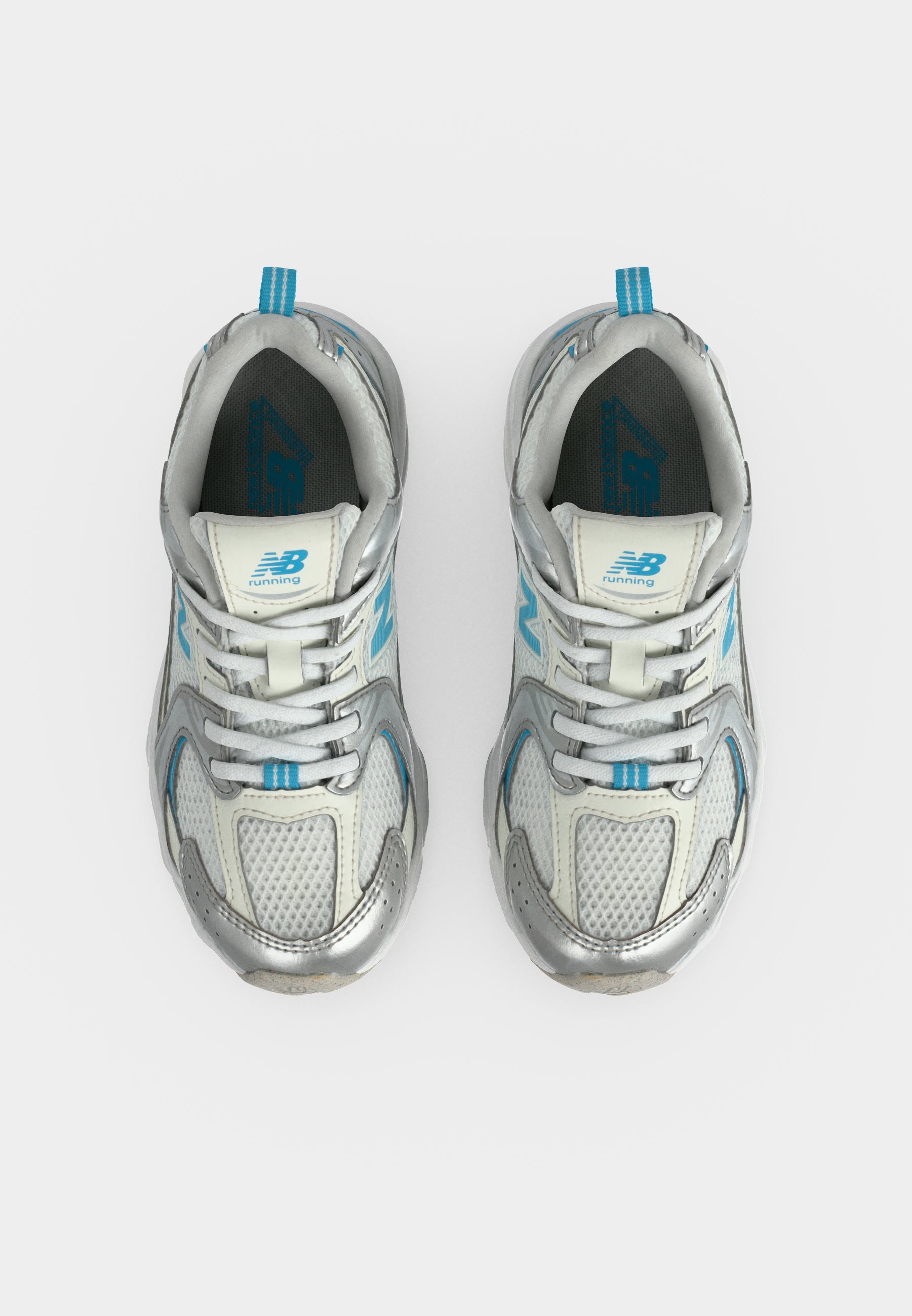 Par de zapatillas de running New Balance plateadas y blancas con detalles en azul, vistas desde arriba sobre un fondo blanco.