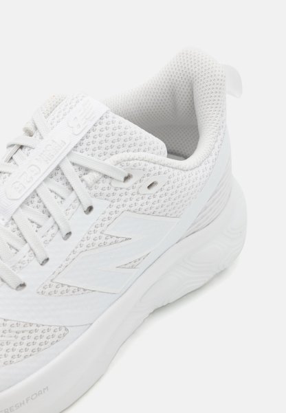 Zapatilla deportiva blanca hecha de tela de malla con una superficie texturizada, cuenta con cordones, un collar acolchado y una suela gruesa y acolchada.