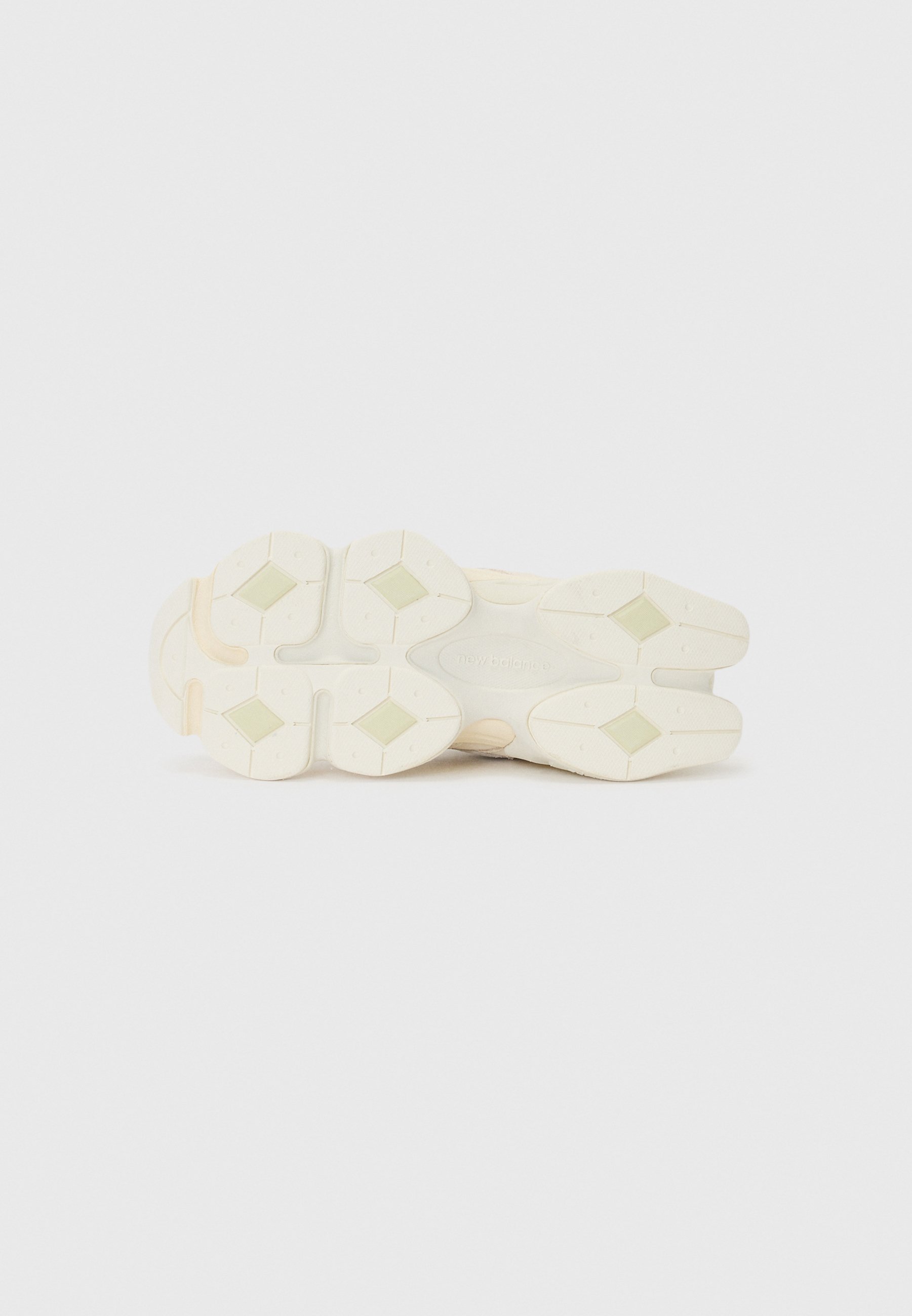 Suela de zapatilla blanca con formas ovaladas y gruesas; presenta acentos de goma de color claro y superficies texturizadas para un mejor agarre.