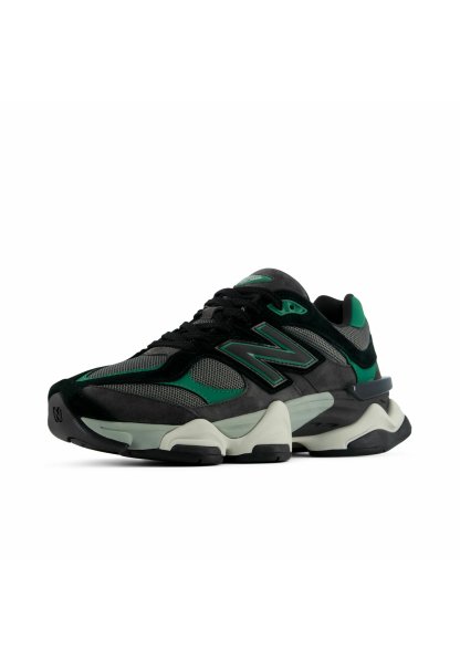 Zapatilla New Balance verde, negra y gris con paneles de malla y ante, suela gruesa acolchada y gran logotipo lateral “N” sobre fondo blanco.
