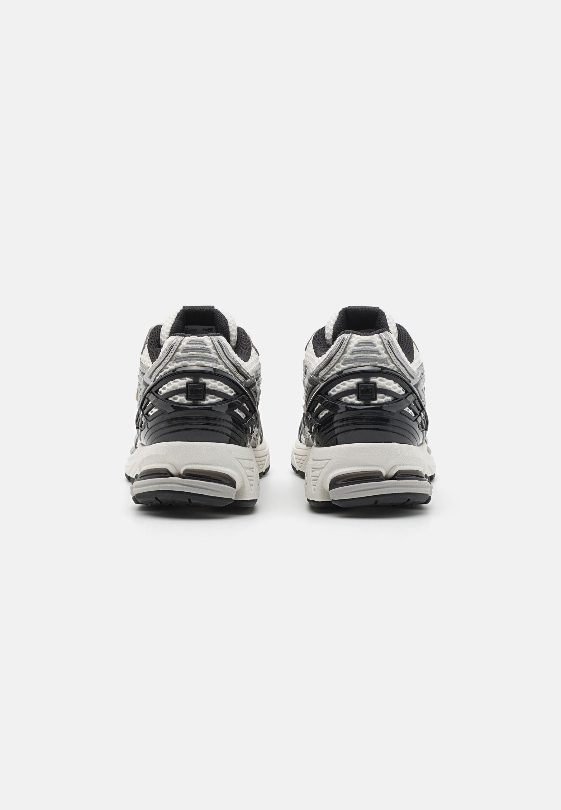 Zapatillas deportivas en negro y gris con superficies texturizadas, hechas de malla y material sintético, que presentan un diseño de cordones y suelas acolchadas.