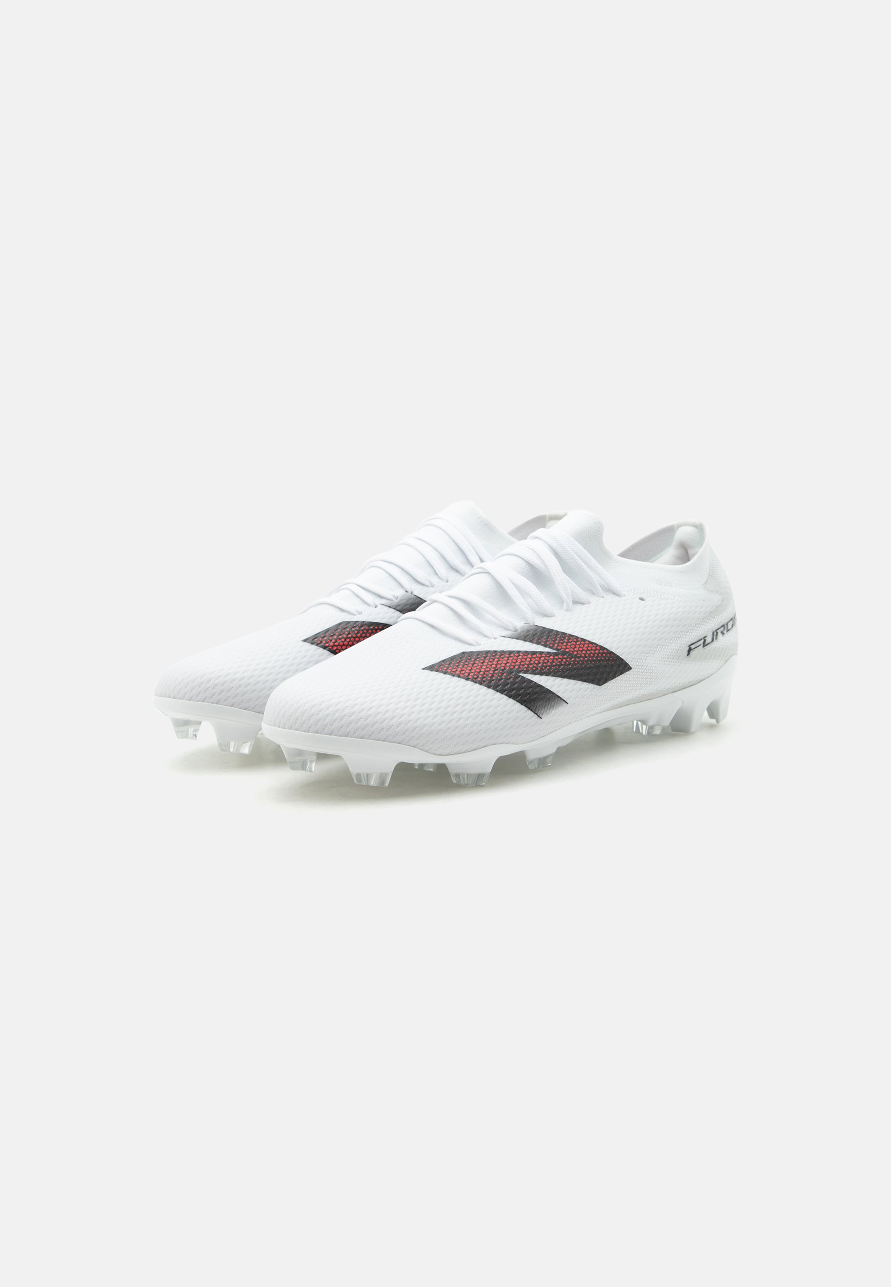 Botas de fútbol blancas con logo rojo y negro, parte superior texturizada y tacos moldeados para jugar en terreno firme, mostradas desde una vista lateral en ángulo.