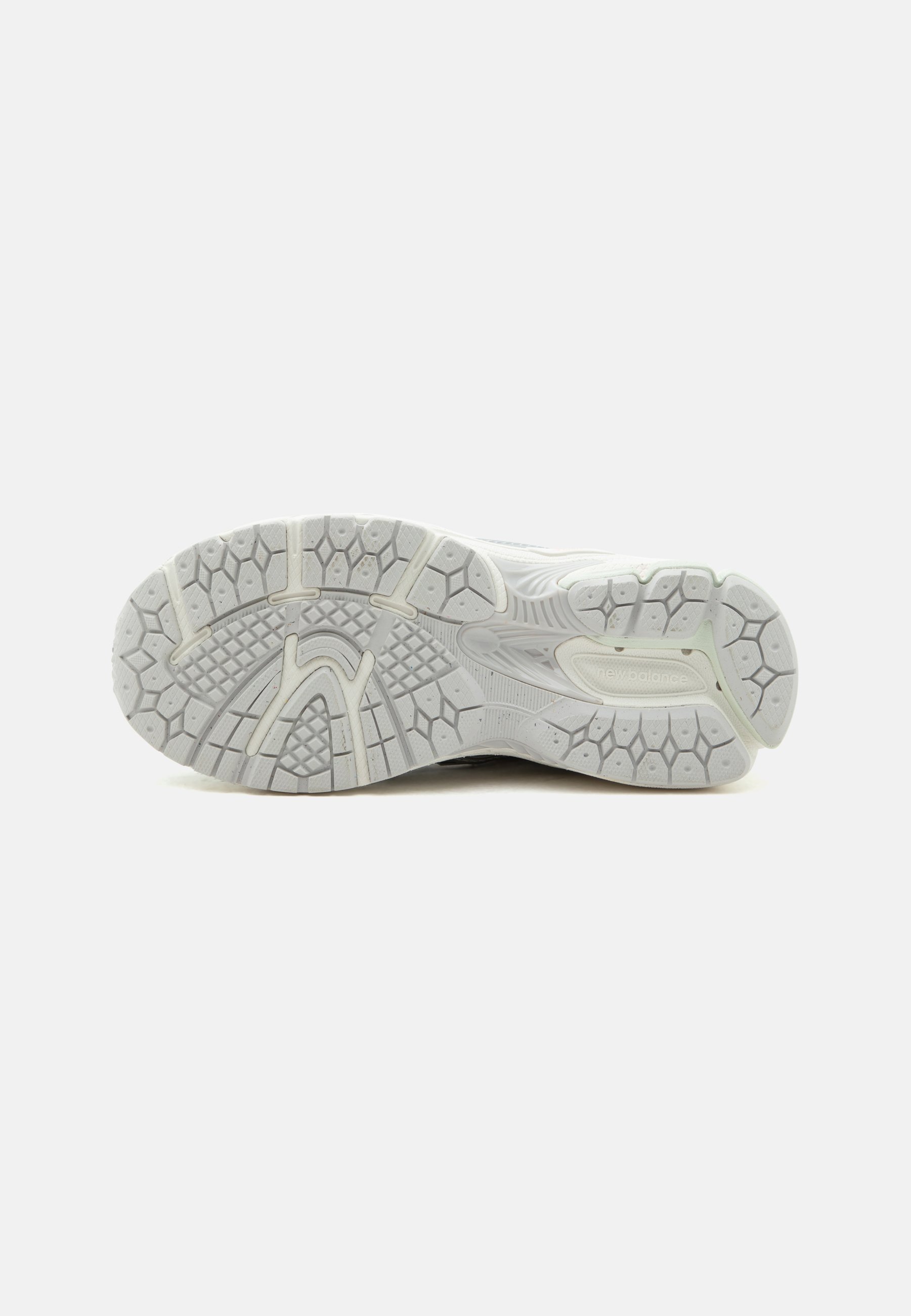 Suela de zapatilla deportiva blanca con patrón de banda de rodadura texturizado y logotipo "new balance" en la zona del talón, mostrada sobre un fondo liso.