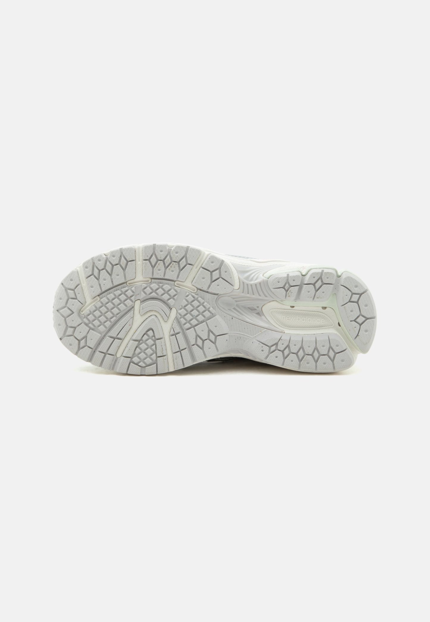 Suela de zapatilla deportiva blanca con patrón de banda de rodadura texturizado y logotipo "new balance" en la zona del talón, mostrada sobre un fondo liso.