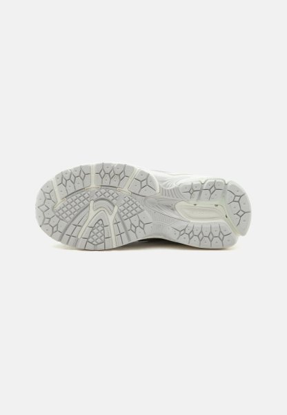 Suela de zapatilla deportiva blanca con patrón de banda de rodadura texturizado y logotipo "new balance" en la zona del talón, mostrada sobre un fondo liso.
