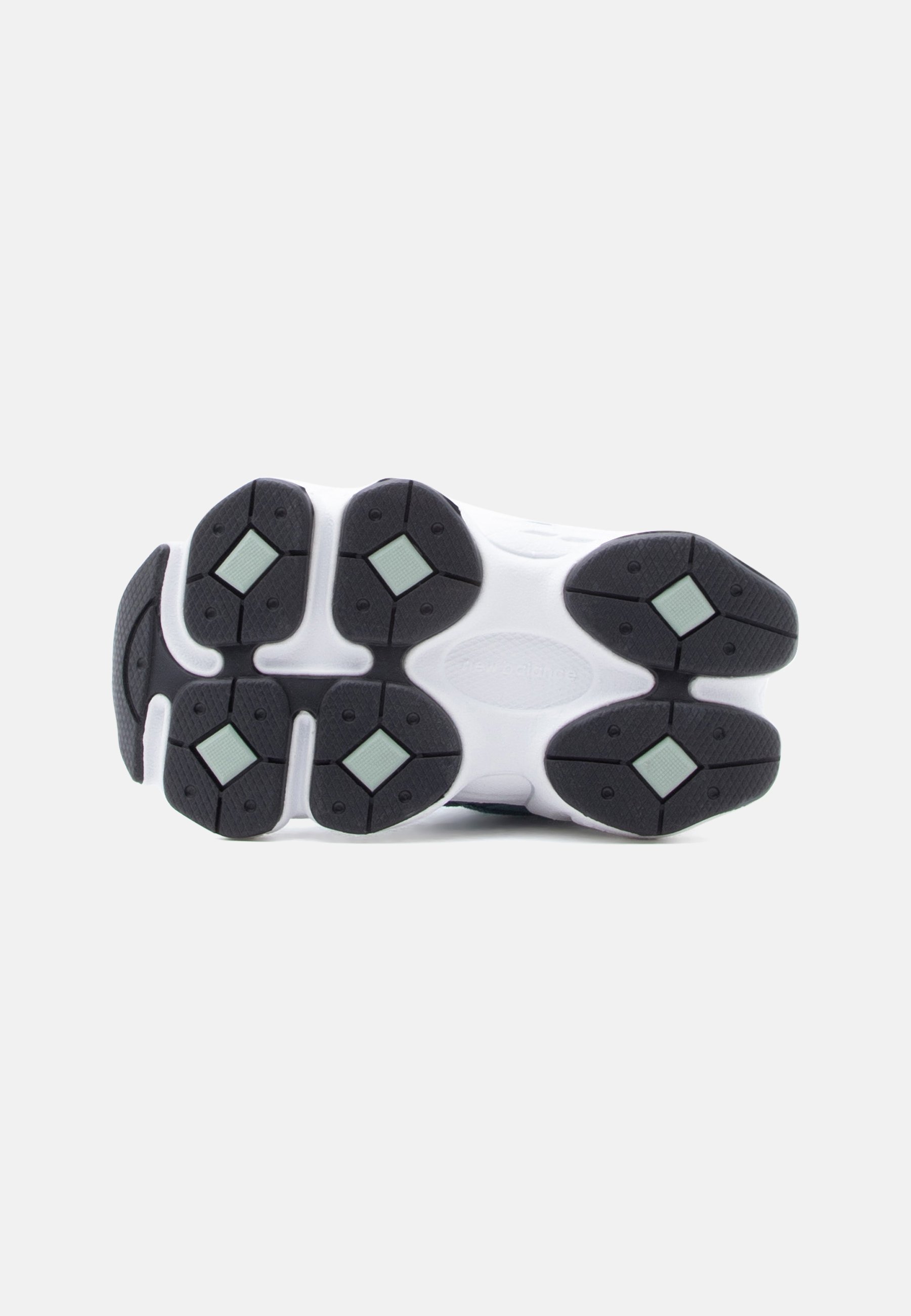 Suela de zapatilla blanca con suelas de goma segmentadas en negro y verde claro, diseñadas para agarre y flexibilidad.